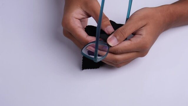 person wiping glasses with black microfiber cloth high angle shot