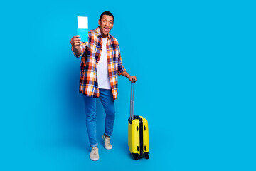 Full length portrait of nice young man suitcase tickets empty space advert wear shirt isolated on blue color background