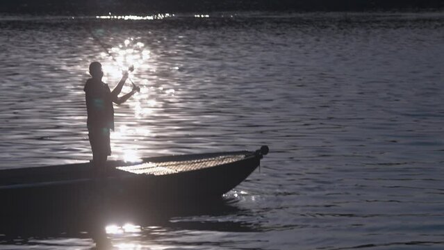 Young man fishing on river boat