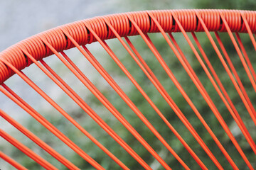Close-up sur des fils en plastique orange d'un fauteuil acapulco - Arrière-plan design abstrait