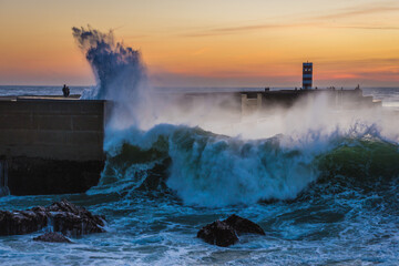 Spectacular waves seen from Atlantic Ocean breakwater in Foz do Douro area during evening in Porto,...