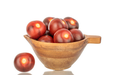 Several ripe black cherry tomatoes with a wooden cup, macro, isolated on white background.