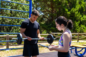 Personal trainer supervising barbell curl workout