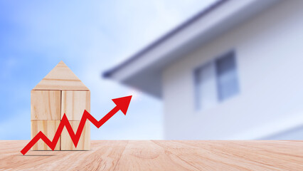 a red up arrow and wooden house. The concept of the rising price of real estate, high demand for...