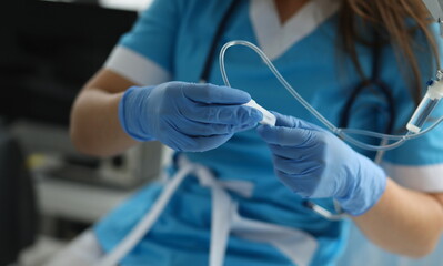 Close-up of medical worker with drop bottle and catheter. Professional female doctor in uniform at hospital. Diagnostic and clinic support. Healthcare and modern medicine concept