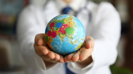 Male doctor hand hold earth with virus symbol closeup. Covid 19 online tracking concept