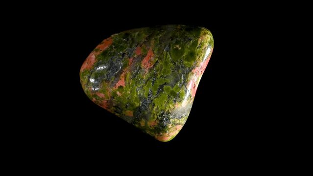 Polished Unakite -  metamorphic granite composed of orthoclase feldspar, epidote and quartz - rotating slowly against a black background.