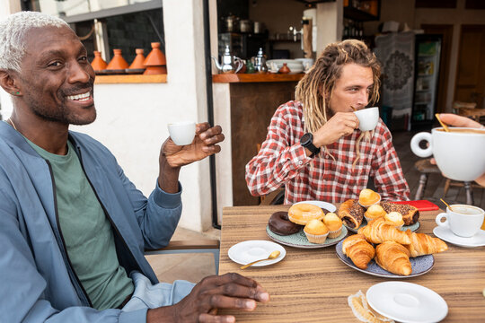 Friends sharing coffee and pastries at cafe