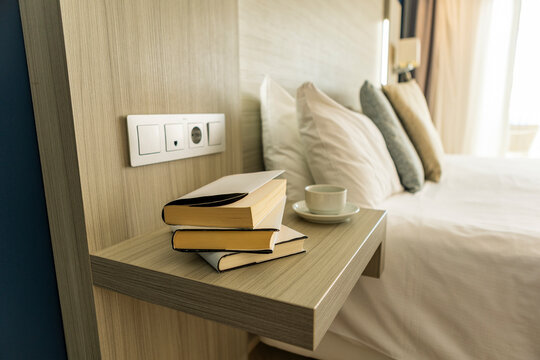Cozy hotel room with books on bedside shelf