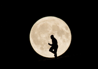 A striking silhouette of a man on one knee, proposing against the backdrop of a full moon, capturing a once-in-a-lifetime romantic moment