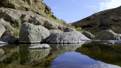 Ravine in the Canary Islands with collected rainwater reflecting the sky. Global warming concept