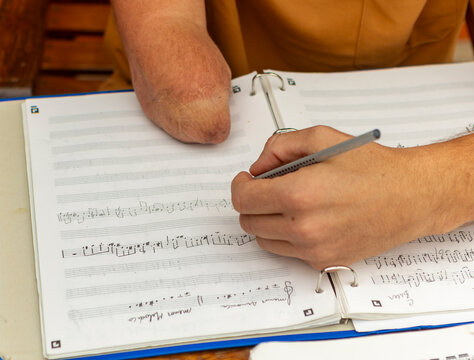One-armed trumpeter composing music at home
