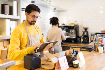 Café owner using tablet to manage orders and payments