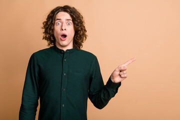 Photo of worried shocked speechless staring man wear trendy green clothes demonstrate empty space...