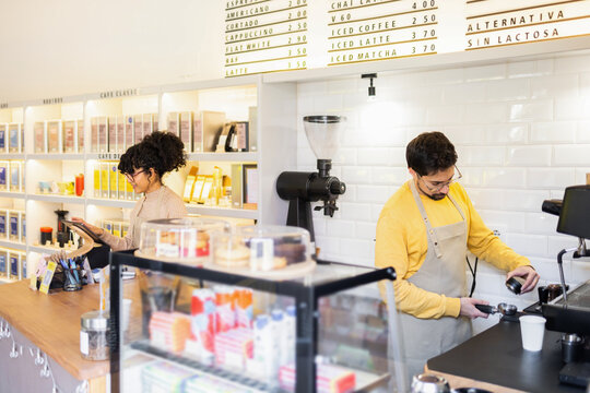 Multiethnic baristas hard at work in a sunny modern cafe