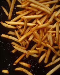 Abundance of Golden French Fries on Dark Background