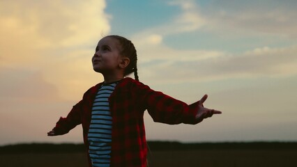 little child kid girl raises her hands sky sunset, religion praying, child praying faithfully,...