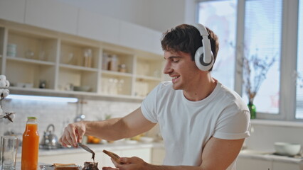 Cooking man dancing headphones singing along favorite song at kitchen close up.