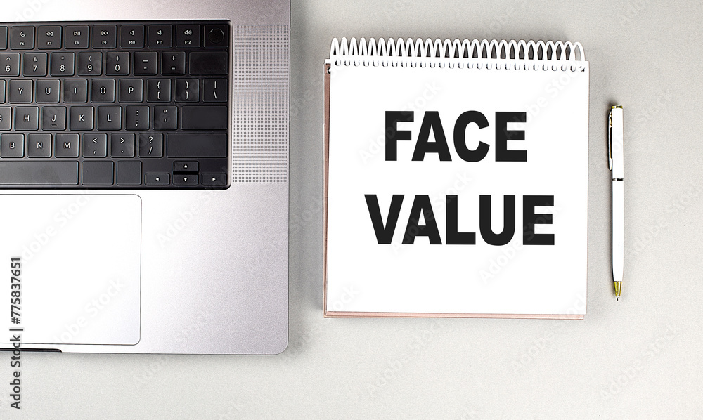 Poster face value text on notebook with laptop and pen