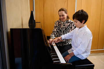 Female music teacher explaining piano lesson to her student during individual music lesson at home....