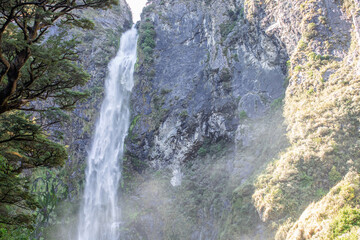 Devils Punchbowl waterfall cascades amid lush NZ greenery, a jewel of Arthur's Pass