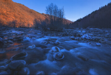 beautiful frosty sunrise over fast flowing mountain river