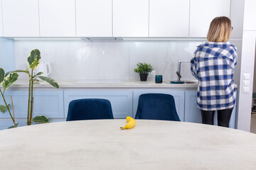 A housewife stands with her back to a modern kitchen.