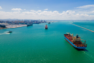 the image provides a stunning aerial view of a bustling cargo ship port, where massive vessels dock...
