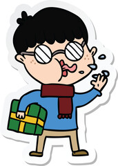 sticker of a cartoon boy wearing spectacles with christmas gift