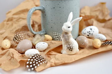 Easter composition with white rabbit, eggs and feathers on a brown kraft paper background. Easter still life - 775862087