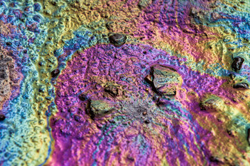 Spilled rainbow gasoline on the asphalt, abstract background