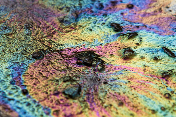 Spilled rainbow gasoline on the asphalt, abstract background
