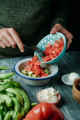 man prepares a spanish salad with broad beans