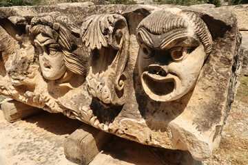 Big stone with ancient relief of three theater masks in the ancient town of Myra, near Demre, Turkey