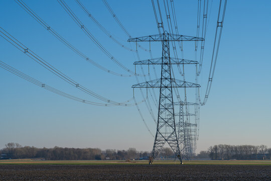 A row off electrical towers in the Dutch countryside.
