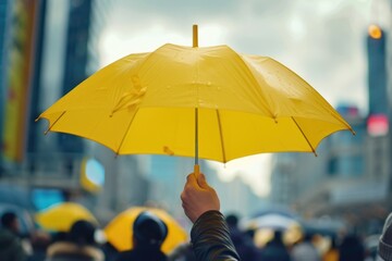 A person holding a yellow umbrella in the rain. Suitable for weather or outdoor concepts