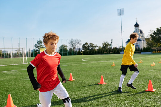 Two young men are passionately playing a game of soccer on a grassy field. They dribble, pass, and shoot the ball, showcasing skill and teamwork in their gameplay. - Powered by Adobe