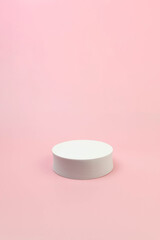 White round podium on pink background. Geometric abstract shape for cosmetic product presentation. Copy space.