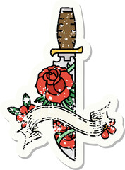 worn old sticker with banner of a dagger and flowers