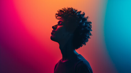 Silhouette of a Young Man Against a Vivid Red and Blue Gradient Background - 775921406