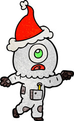 hand drawn textured cartoon of a cyclops alien spaceman pointing wearing santa hat
