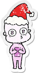 hand drawn distressed sticker cartoon of a weird bald spaceman wearing santa hat