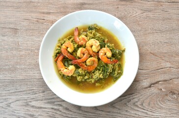 spicy fried shrimp with egg and slice celery couple spring onion in yellow curry sauce on plate