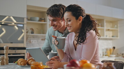 Romantic couple shopping online at family breakfast close up. Pair using gadget