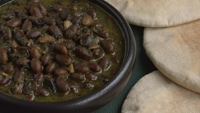 Black soybean curry. Some pita breads on the side. Close-up while rotating.  