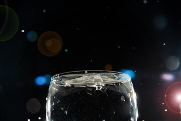 Transparent glass bowl filled with water with splashes of water around it. Splash Effect.