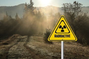 Radioactive pollution. Yellow warning sign with hazard symbol in mountains
