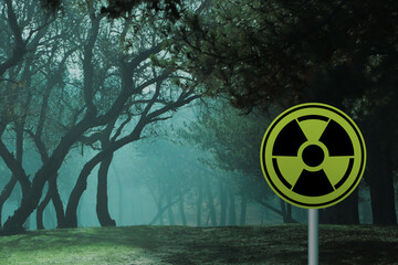 Radioactive pollution. Yellow warning sign with hazard symbol in forest