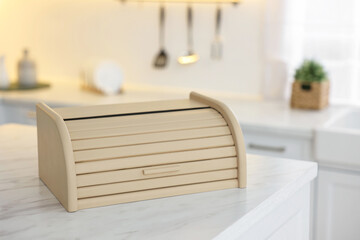 Wooden bread box on white marble table in kitchen