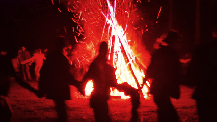Huge fire at night and young people around. Pagan festival of Walpurgis night: bonfires, dancing wildly, witches. Figure of Witches Queen (HexenkР“В¶nigin). German legends, St. Walburgas and Satanism